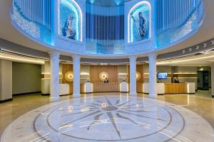 a large lobby with a clock in the center of a building at Limak Atlantis Deluxe Hotel Belek in Belek