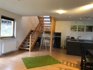 a living room with a staircase and a kitchen at Haus Kleewiese in Ulmen