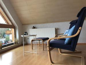 Zimmer mit 2 Stühlen, einem Tisch und einem Fenster in der Unterkunft Haus Kleewiese in Ulmen