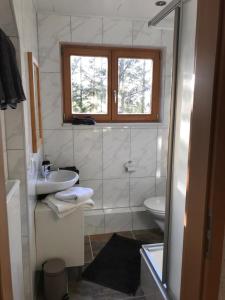 a white bathroom with a sink and a toilet at Haus Kleewiese in Ulmen