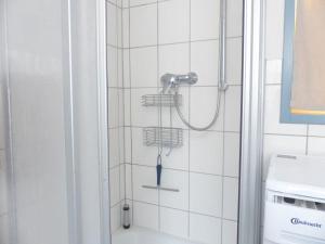 La salle de bains est pourvue d'une douche et de carrelage blanc. dans l'établissement Ehemalige Rosengärtnerei, à Randersacker