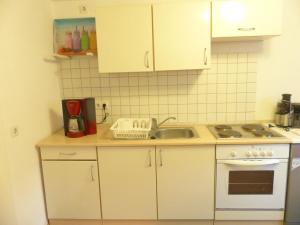 a kitchen with white cabinets and a sink at Ehemalige Rosengärtnerei in Randersacker