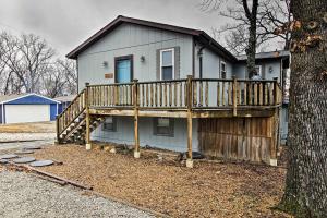 une maison avec une terrasse en bois et un arbre dans l'établissement Stockton Lake Escape with Kitchen, Half Mile to Lake, à Stockton