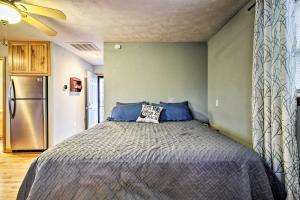 ein Schlafzimmer mit einem Bett mit blauen Kissen und einem Kühlschrank in der Unterkunft Stockton Lake Escape with Kitchen, Half Mile to Lake in Stockton