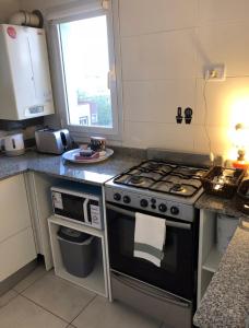 a kitchen with a stove and a window in it at Depto nuevo boutique, muy luminoso a 6 cuadras de la playa in Mar del Plata