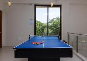 - une table de ping-pong bleue dans une pièce vide dans l'établissement StayVista's Greenwoods Villa 6 - City-Center Villa with Private Pool, Terrace, Lift & Ping-Pong Table, à Lonavala