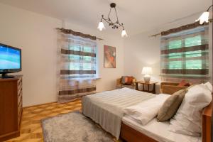 a bedroom with a bed and a flat screen tv at Willa Ostoja in Kazimierz Dolny