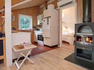 - une cuisine avec un poêle à bois dans une chambre dans l'établissement Peaceful Holiday Home in L kken 500 M from the Ocean, à Lønstrup