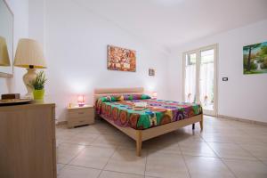 a bedroom with a bed and a table and a window at House Rita Marzamemi in Marzamemi +31 photos