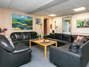 Grønhøjにある24 person holiday home in L kkenのリビングルーム(革張りのソファ、コーヒーテーブル付)