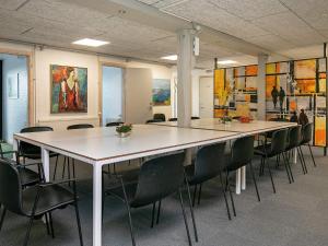 una sala de conferencias con una mesa grande y sillas en 24 person holiday home in L kken, en Grønhøj