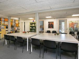 duas mesas numa sala com cadeiras e pinturas em 24 person holiday home in L kken em Grønhøj