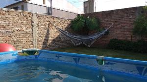 a swimming pool with a hammock in a backyard at Mysa's home in Monte Grande