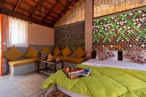 sypialnia z łóżkiem i kanapą w pokoju w obiekcie The Hammock Goa w mieście Anjuna