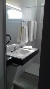 a bathroom with a sink and a mirror and towels at Apartamentos Pez Azul in Puerto de la Cruz