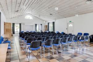 a large room with blue chairs in a classroom at Villa Beddingestrand in Beddinge Strand