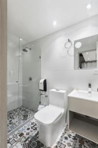 a white bathroom with a toilet and a sink at 3H HOTEL Av 70 in Medellín