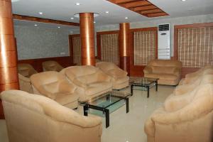 una sala de estar con sillas, mesas y columnas en KPM Regency, en Palakkad