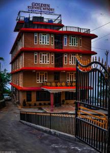 ein großes Gebäude mit einem Zaun davor in der Unterkunft Golden Kuensel Resort & Spa in Kalimpong