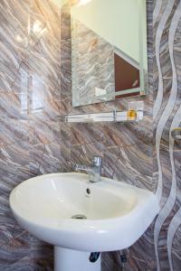 y baño con lavabo blanco y espejo. en Golden Star Continental & Spa, en Gangtok