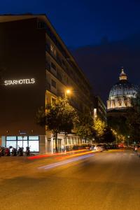 a city street at night with a building and a dome at Starhotels Michelangelo Rome in Rome
