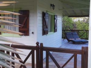 a porch of a house with blue chairs on it at Domaine des Deux Mares in Le Moule +10 photos