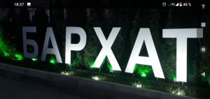 a large white sign that says happyza with green lights at Бархат in Tsandrypsh