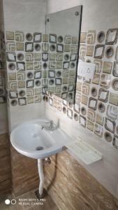 ein Bad mit einem Waschbecken und einem Spiegel in der Unterkunft Sar Raj S R RESIDENCY in Vellore