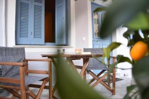 un tavolo e sedie in legno su una veranda con persiane blu di Laundry House a Sinarádes