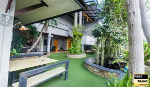 通萨拉First and Frang Hotel - Koh Phangan的天井设有桌子、长椅和植物