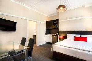 1 dormitorio con cama y mesa de cristal en Como Court Budget Accommodation en Melbourne