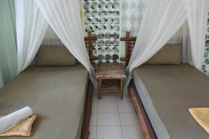 a room with two beds with curtains and a table at Chill Out Bar and Bungalows in Tonsai Beach