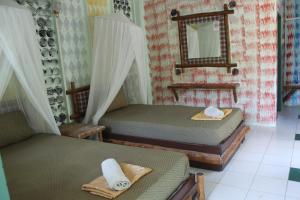 um quarto com 2 camas individuais e um espelho em Chill Out Bar and Bungalows em Tonsai Beach