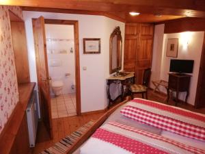 a bedroom with a bed and a bathroom at Alte Schreinerei-Auberge Harlekin in Randegg