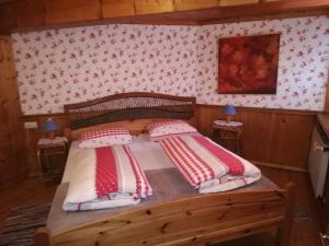 a bedroom with a wooden bed with two pillows at Alte Schreinerei-Auberge Harlekin in Randegg