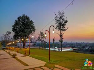 River Valley Resort في نان: حديقة بها أضواء شوارع وطائرة ورقية على العشب