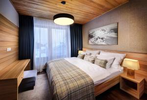 a bedroom with a bed and a large window at Chalet Norvinga Jasná in Demanovska Dolina