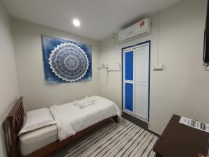 a bedroom with a bed and a painting on the wall at De Chukai Hotel in Kampong Kemaman