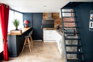 eine Küche mit blauen Wänden und einer Wendeltreppe in der Unterkunft Le cottage du clos des Forges in Saint-Leu-dʼEsserent