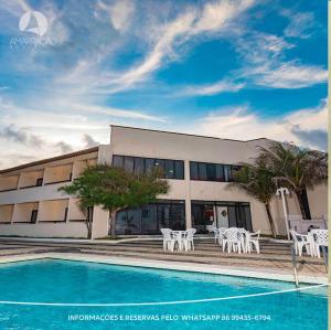 a building with a pool in front of a building at Hotel Amarração in Luis Correia