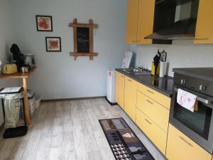 a kitchen with yellow cabinets and a stove at Ferienhaus Alt Bahnhaus in Ruschberg