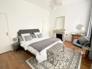 een slaapkamer met een groot bed en een stoel bij Manoir 1838 à - 3 km du Zoo de Beauval & proche des châteaux in Saint-Aignan
