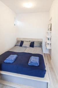 una camera da letto con un letto con coperte blu sopra di Cosy Apartment in Sopot a Sopot