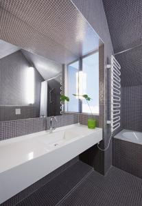 a bathroom with a sink and a mirror and a tub at Hotel König von Ungarn in Vienna