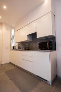 uma cozinha com armários brancos e um micro-ondas em Cosy studio in the greenest corner of Trastevere em Roma
