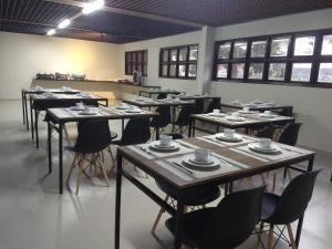 a room with tables and chairs with cups on them at Pousada Ariús in Campina Grande