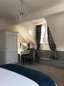 a bedroom with a bed and a desk and a window at No 6 B&B in Landivy