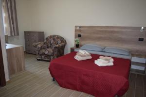 una camera con un letto con una coperta rossa e una sedia di Affittacamere Villa Paolina a Sala Consilina