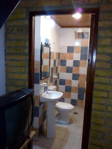 TV y baño con lavabo y aseo. en DEPARTAMENtO LOFT en Posadas