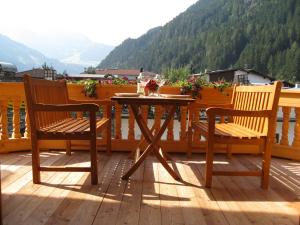 una mesa de madera y 2 sillas en una terraza en Das Edelweiss, en Aschau